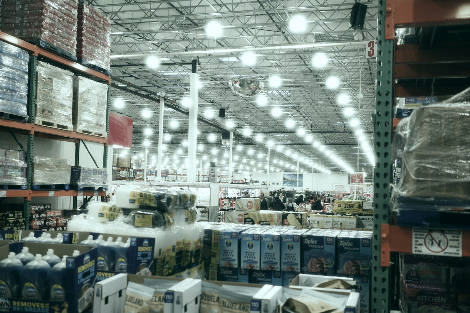 Conveyor lines move packed cardboard cartons through a brightly lit logistics warehouse.