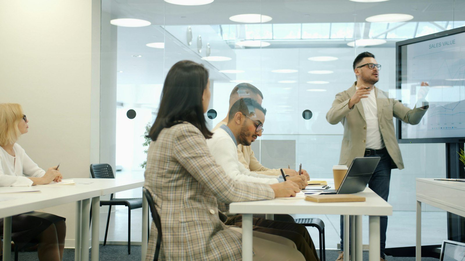 Professionals seated around a long conference table with printed documents during a meeting.