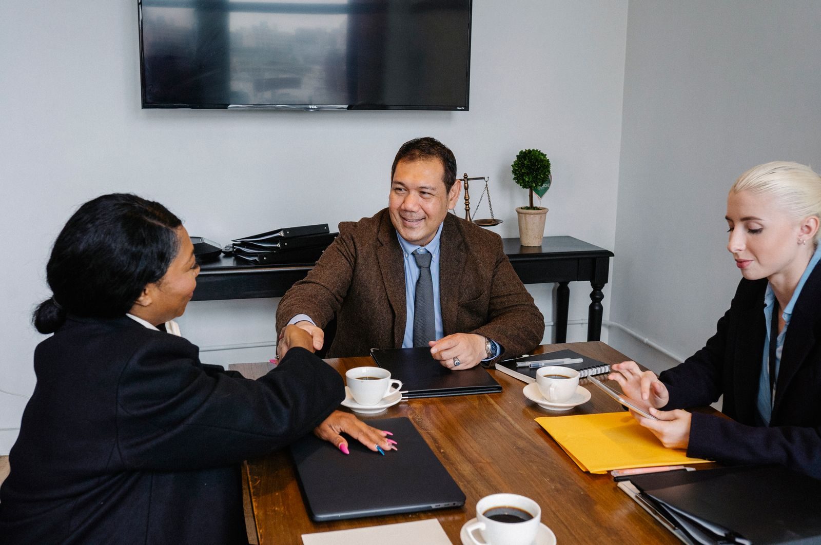 Investors gathered around a conference table reviewing financial documents in warm light.